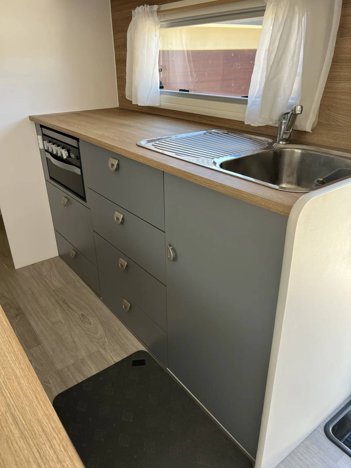 Dark Conni floor mat on the caravan kitchen floor beside the sink